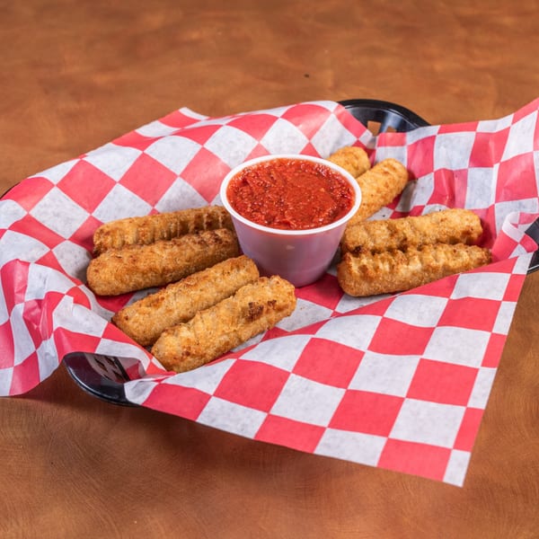 A basket of golden-brown mozzarella sticks with a side of marinara sauce on a red and white checkered liner.